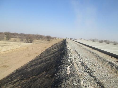 Placing of geomesh at embankment slopes